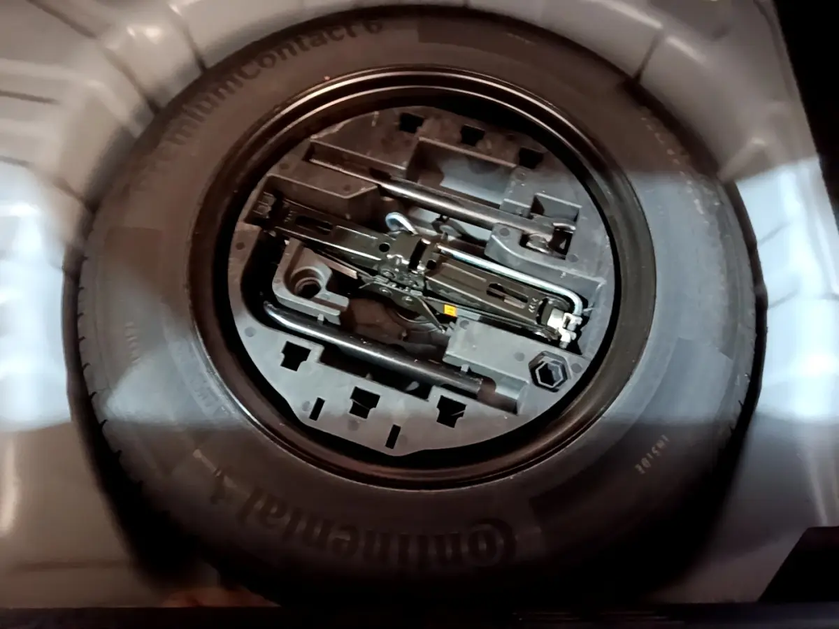 Gros plan sur la roue de secours et les outils de bord dans le coffre d’une Renault Clio gris foncé 2022.