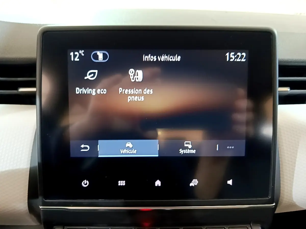 Écran tactile central de la Renault Clio gris foncé, affichant les infos véhicule et la pression des pneus.