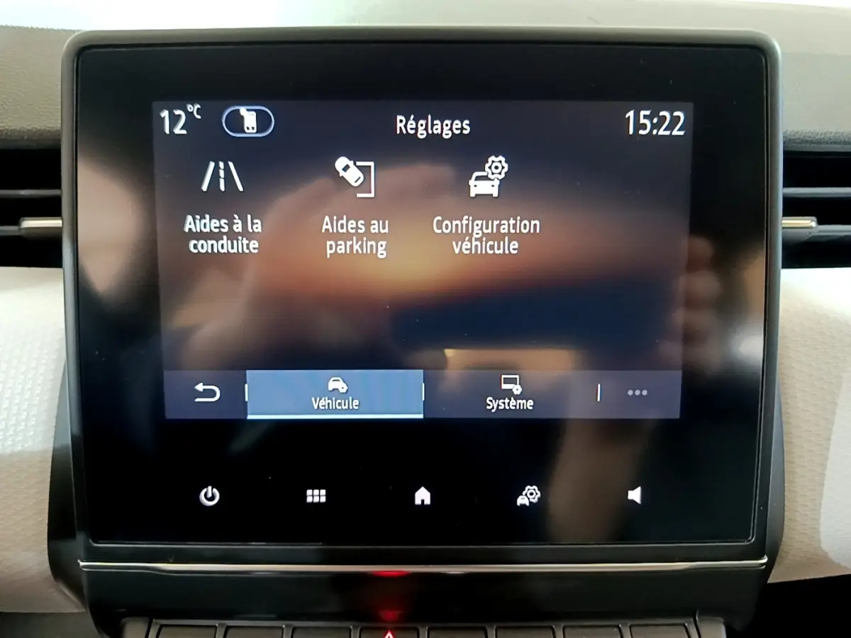 Écran tactile central de la Renault Clio gris foncé 2022 affichant les réglages d’aides à la conduite et au parking.