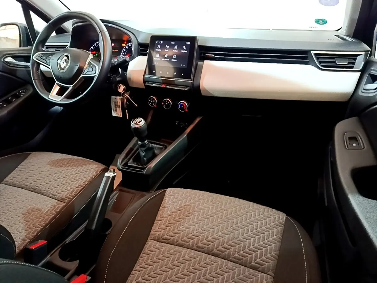 Vue intérieure avant droite de la Renault Clio Evolution SCe 65 2022, tableau de bord clair et écran tactile central.