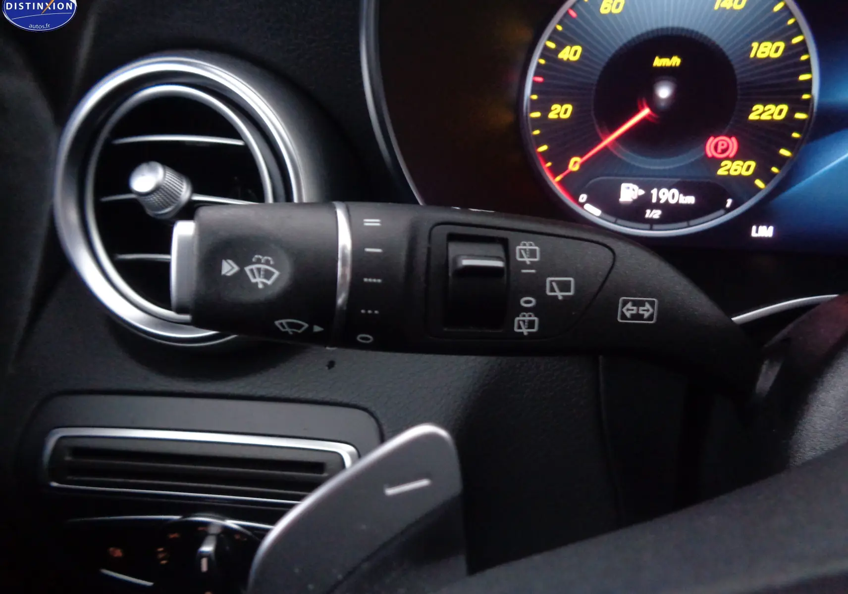 Gros plan sur la commande d’essuie-glace à gauche du volant dans l’habitacle noir du Mercedes Classe C Break 220D AMG Line.