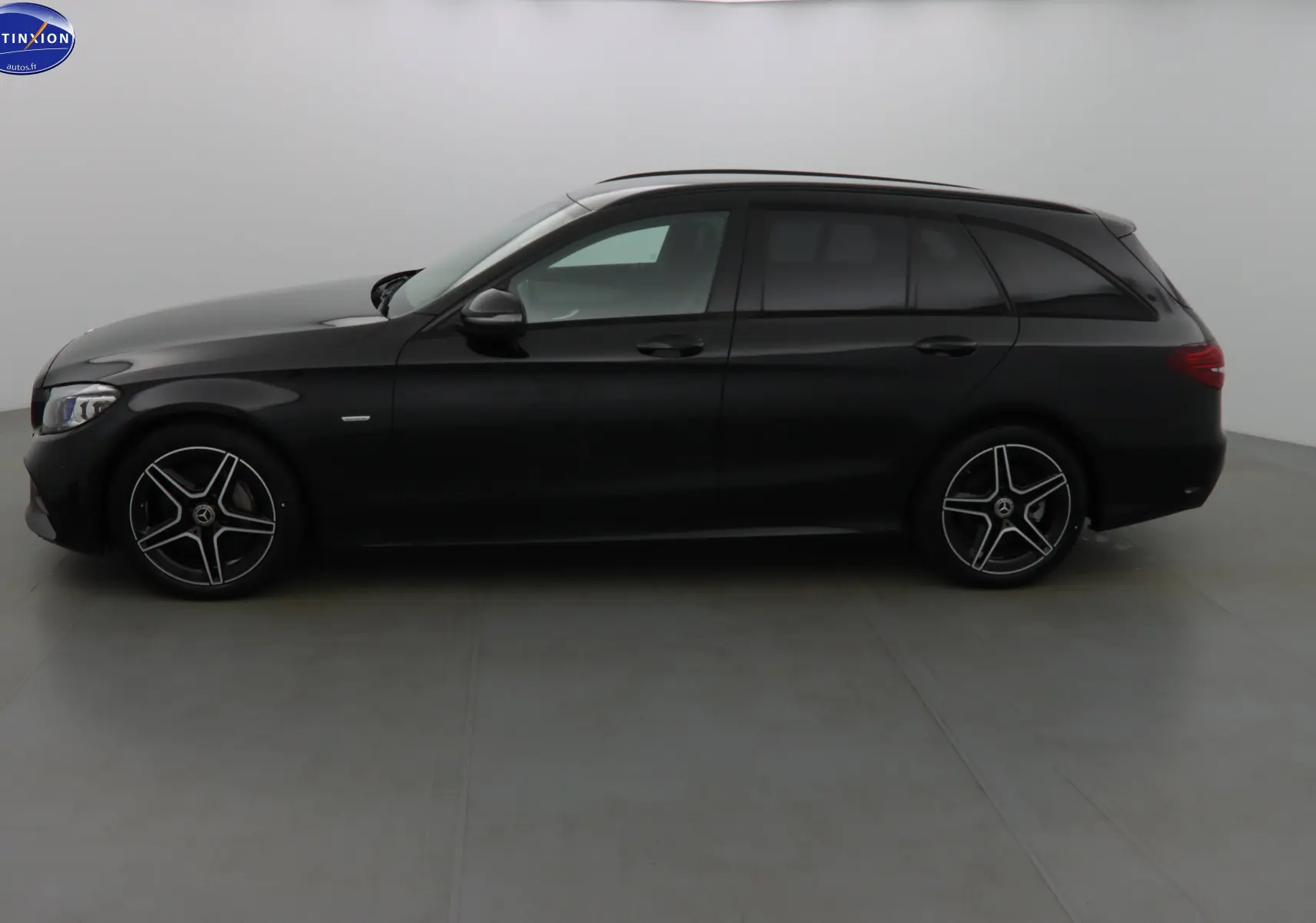 Profil côté gauche d'un break Mercedes Classe C 220D AMG Line noir métal avec jantes alliage 5 branches.