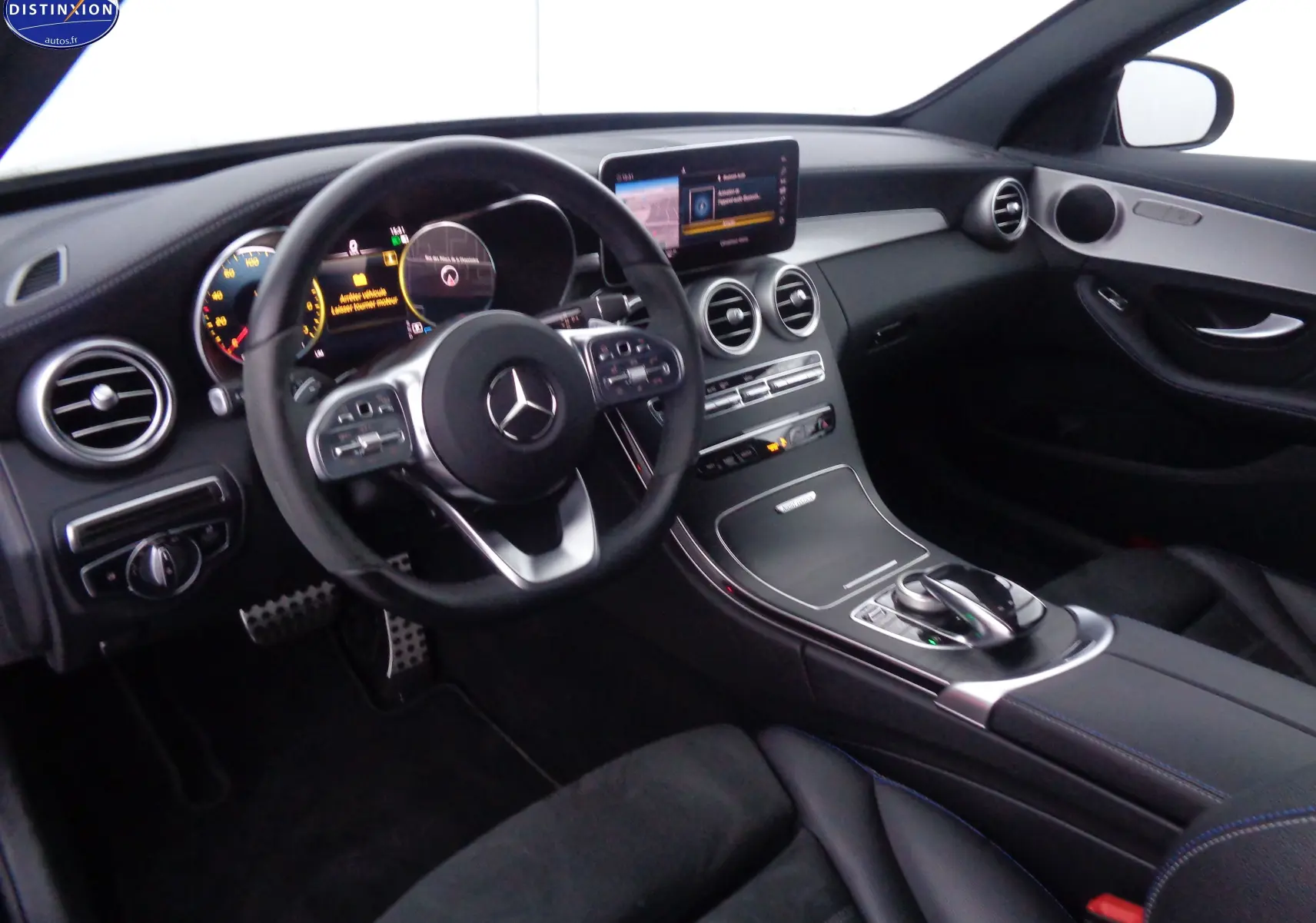 Vue intérieure côté conducteur d'une Mercedes Classe C Break 220D AMG Line 2021 avec tableau de bord noir et écran central.