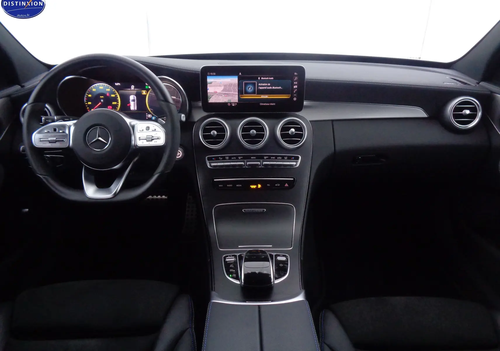 Vue intérieure avant du tableau de bord noir et volant Mercedes avec écran central tactile allumé sur Classe C Break AMG Line 2021.