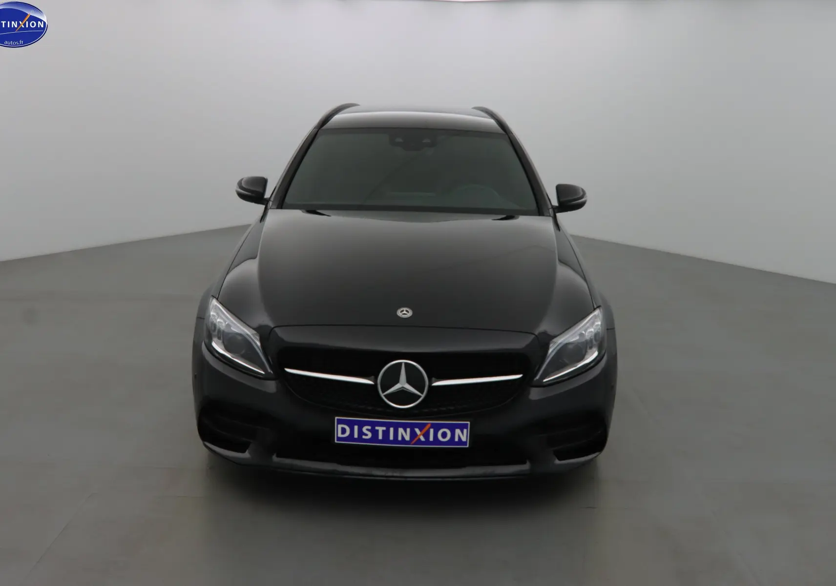 Mercedes Classe C Break 220D noir métal vue de face, mettant en valeur la calandre AMG et les phares LED distinctifs.