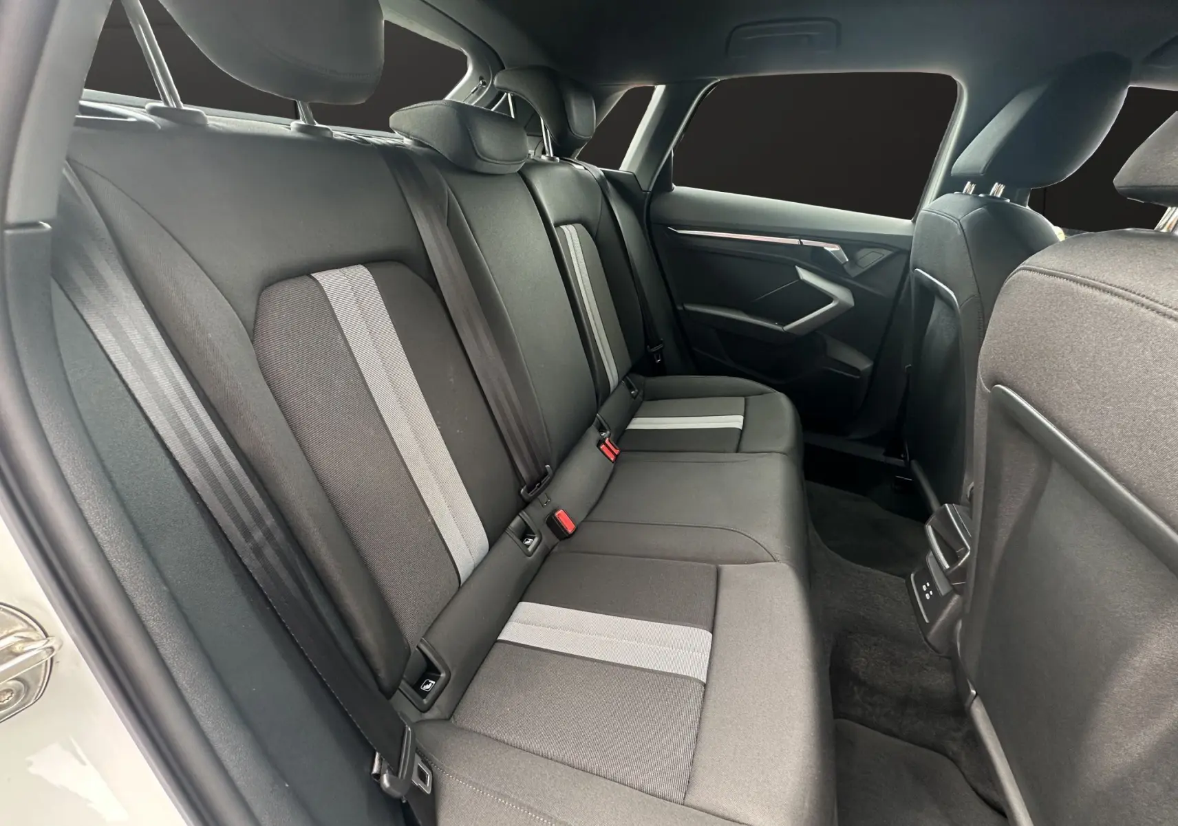 Vue intérieure côté droit des sièges arrière en tissu noir et gris de l'Audi A3 Sportback 2024 finition Advanced Edition.