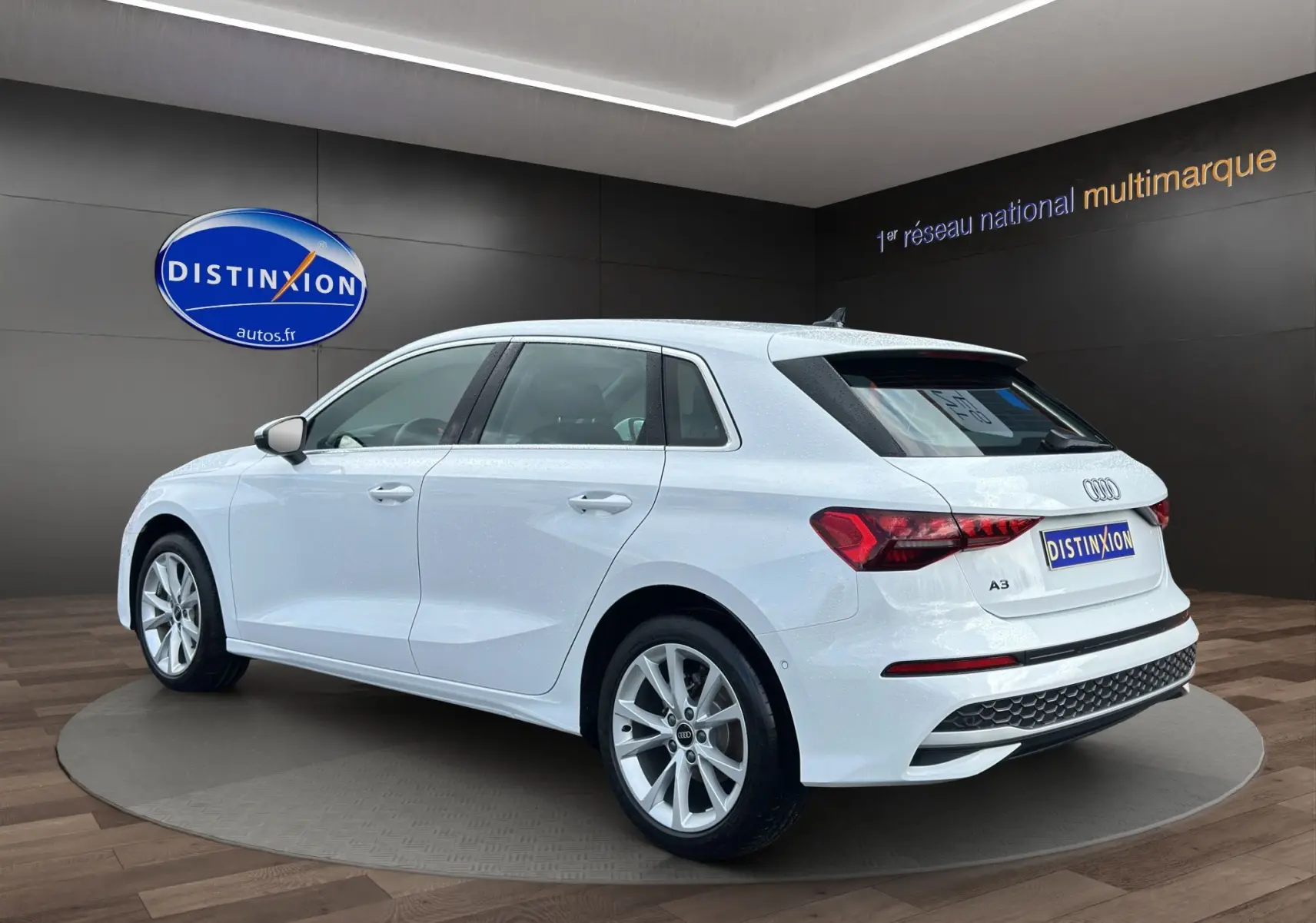 Audi A3 Sportback blanc Arkona vue 3/4 arrière droit, jantes alliage léger et feux LED distinctifs.