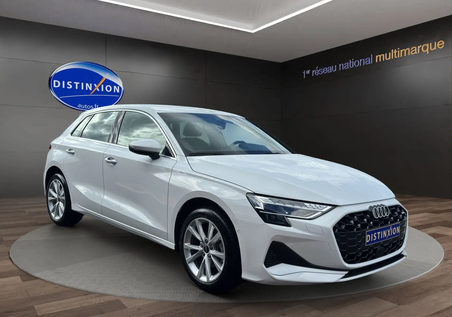 Audi A3 Sportback blanc Arkona vue 3/4 avant droit, avec calandre noire à motif nid d'abeille et jantes alliage.