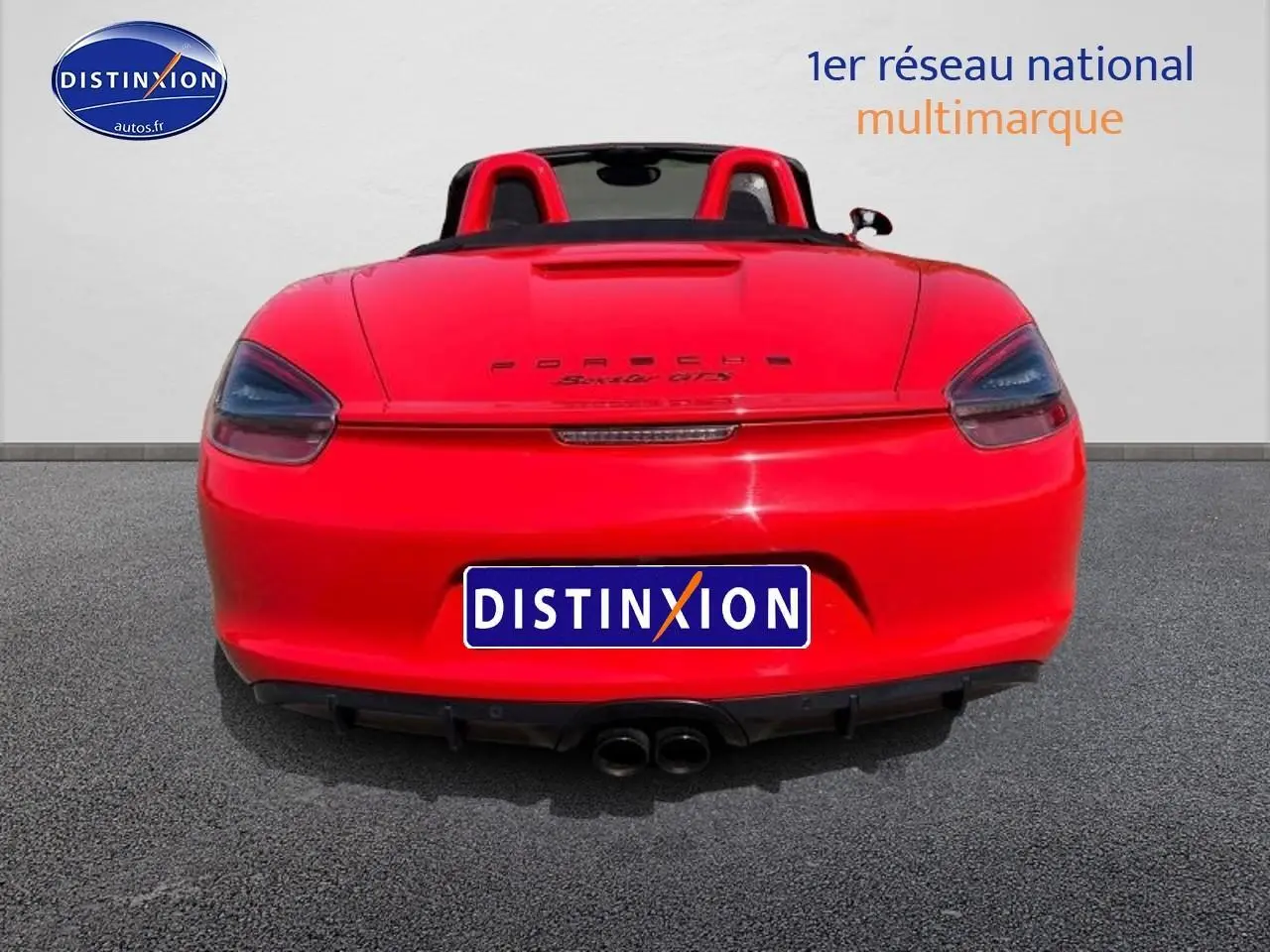Vue arrière d'une Porsche Boxster 981 rouge avec double sortie d'échappement et becquet arrière visible
