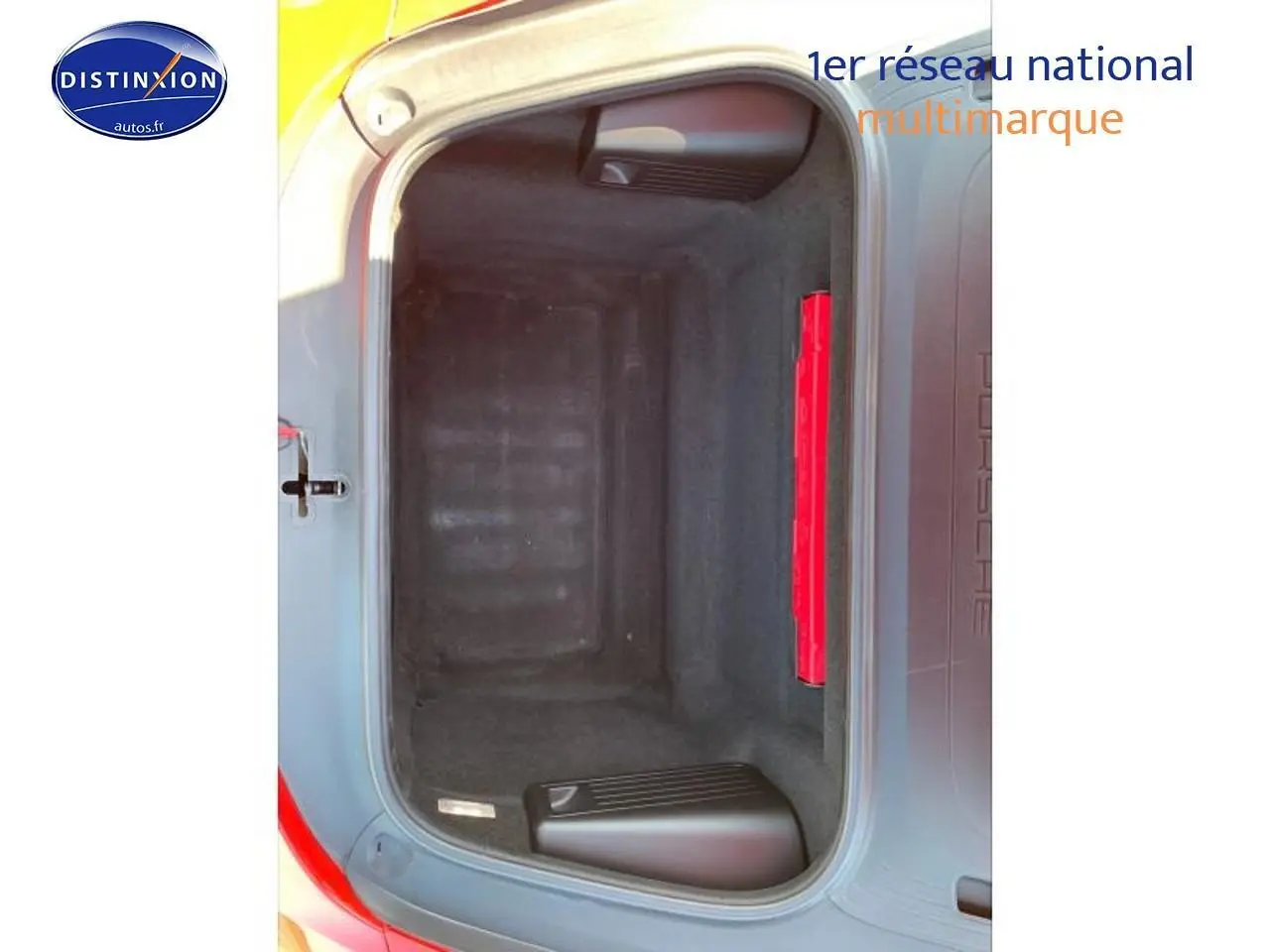 Coffre avant ouvert d'une Porsche Boxster 981 rouge, montrant l'espace de rangement vide et la trappe intérieure.