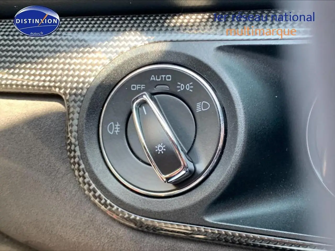 Sélecteur de phares avec finition carbone dans l'habitacle d'une Porsche Boxster rouge (981) 2015.