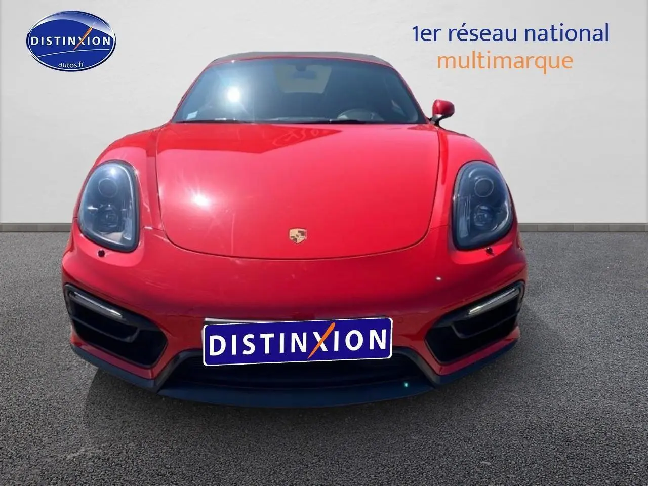 Vue frontale d'une Porsche Boxster rouge 2015 avec phares bi-xénon et boucliers couleur caisse.