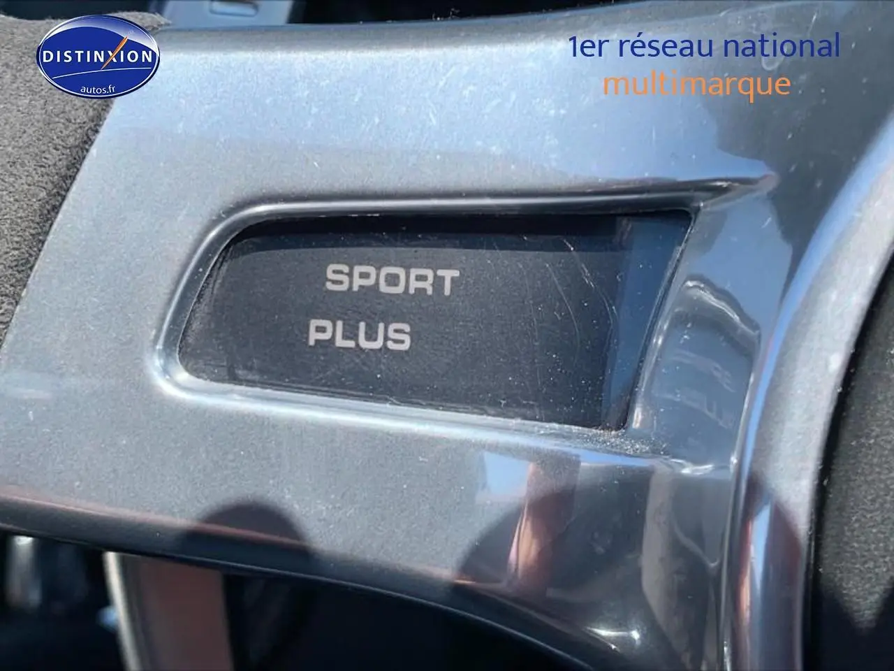 Gros plan sur le bouton "Sport Plus" en finition alu à l'intérieur d'une Porsche Boxster rouge (981) 2015.