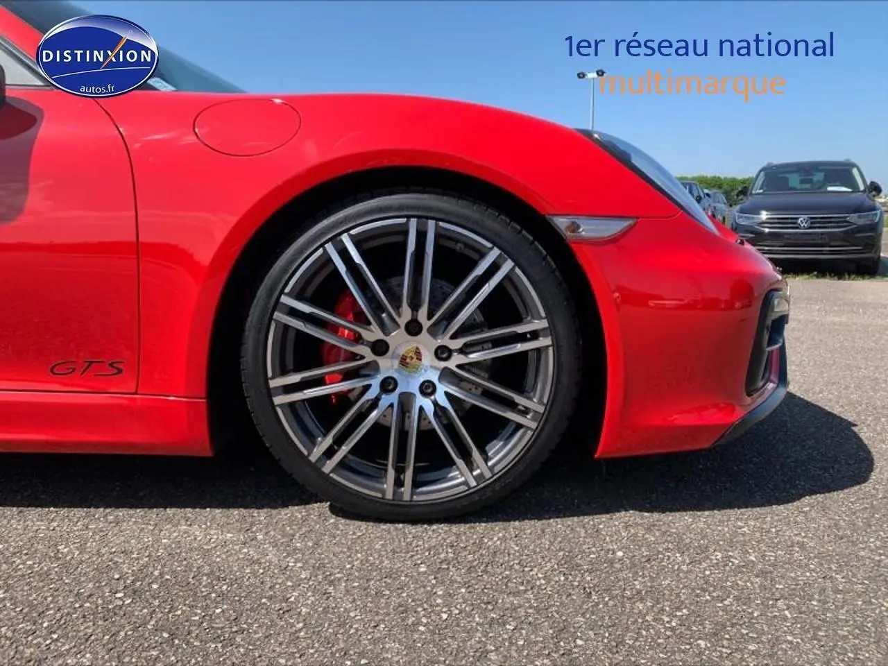 Gros plan sur la roue avant droite d'une Porsche Boxster GTS rouge avec jante alu et étrier de frein rouge.
