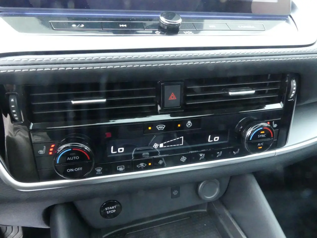 Détail de la console centrale avec climatisation bi-zone et commandes chauffantes du Nissan Qashqai 1.5 e-Power 2025.