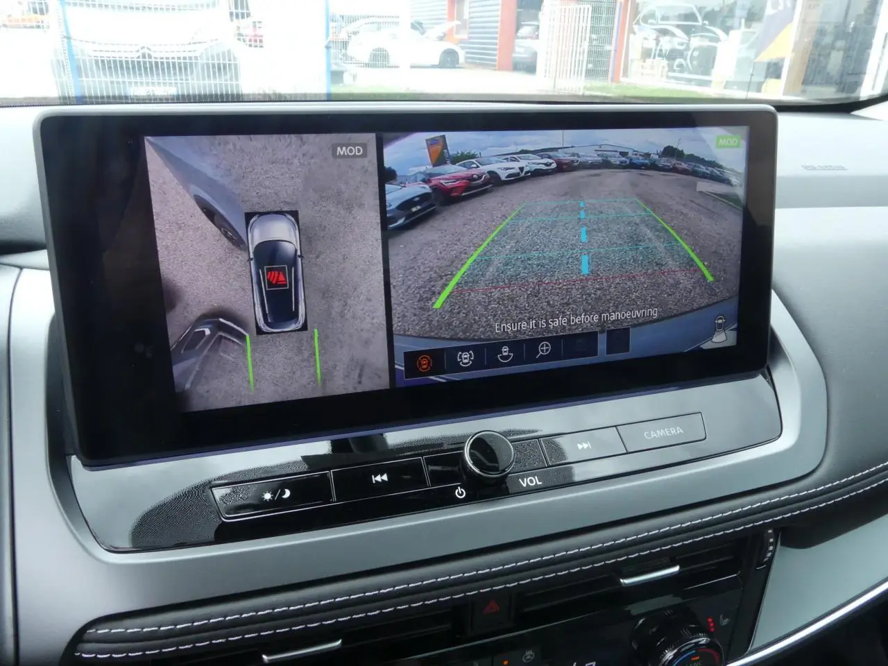 Écran central du Nissan Qashqai 2025 montrant la caméra de recul et la vue à 360° en intérieur gris clair.