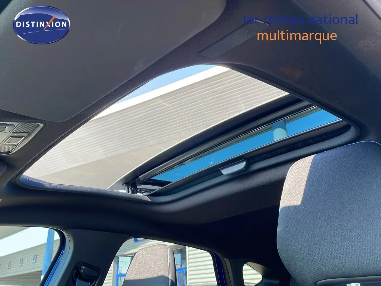 Toit ouvrant panoramique ouvert sur l'intérieur d'un Renault Captur E-Tech hybride 2025, sièges tissu gris visibles.