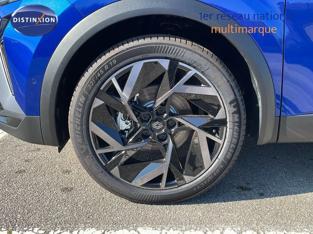 Gros plan sur la jante avant droite noire et argent du Renault Captur bleu Iron Metal 2025.