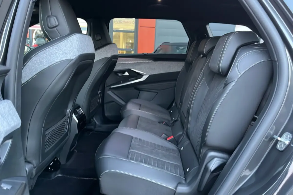 Vue latérale droite de l’intérieur arrière du Peugeot 5008 Hybrid GT, sièges en cuir Alcantara noir avec surpiqûres blanches.