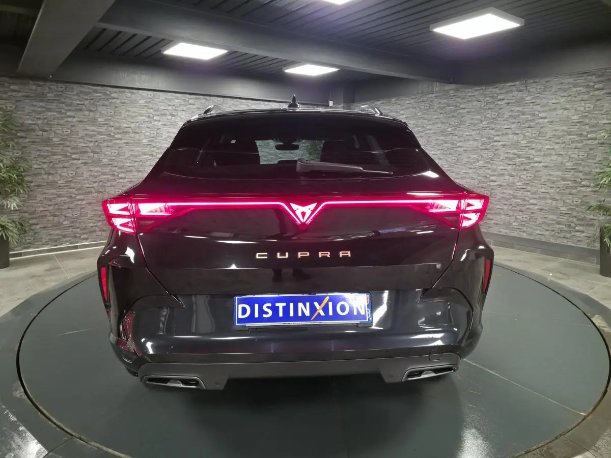 Vue arrière d'un CUPRA Formentor noir 2025 avec signature lumineuse LED en bandeau et double sortie d'échappement.