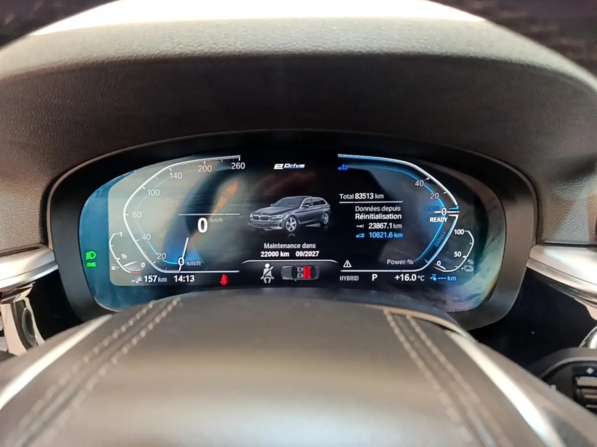 Vue rapprochée du tableau de bord numérique de la BMW Série 5 Touring 530e hybride, affichant les données de conduite.