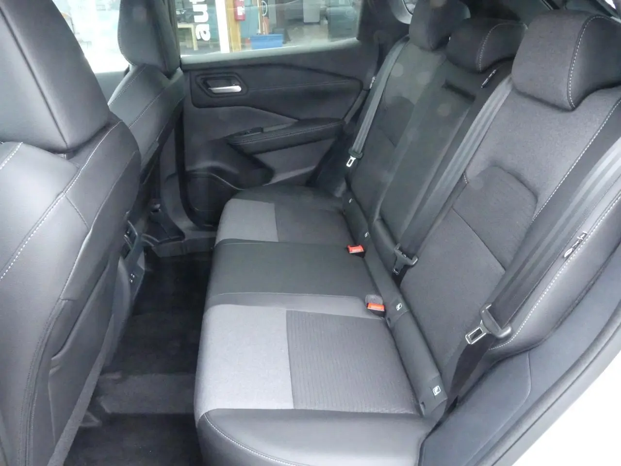 Banquette arrière bi-ton gris et noir du Nissan Qashqai 1.5 e-Power, vue côté droit avec ceintures et appuie-têtes.