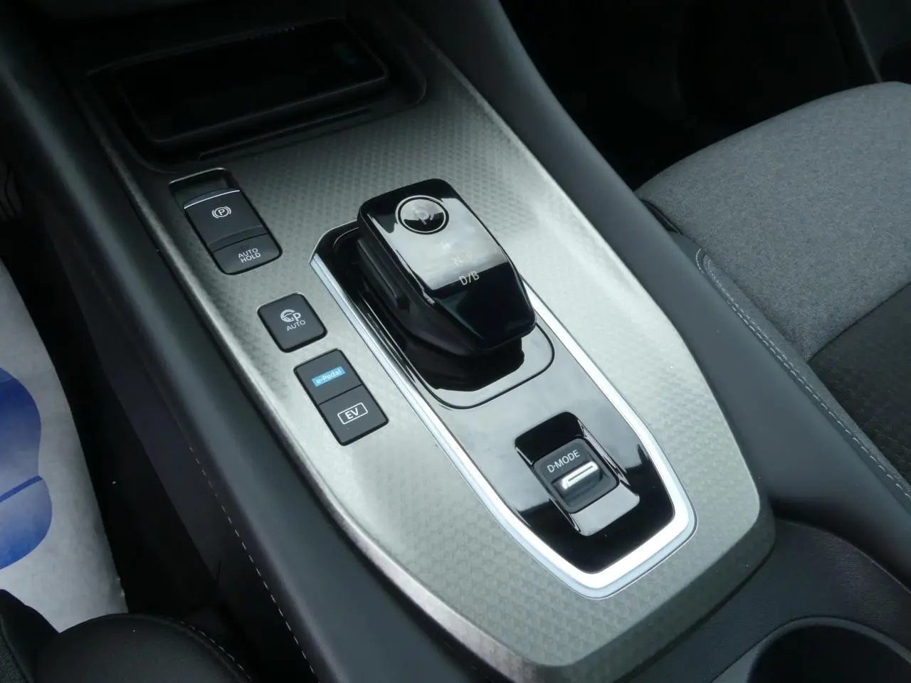 Vue rapprochée de la console centrale du Nissan Qashqai 1.5 e-Power, avec levier de vitesse et boutons de mode.