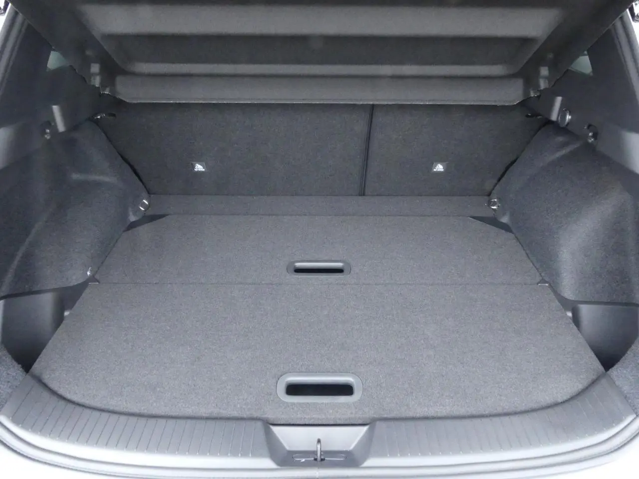 Coffre spacieux du Nissan Qashqai 1.5 e-Power gris métallisé avec plancher modulable et poignées intégrées.