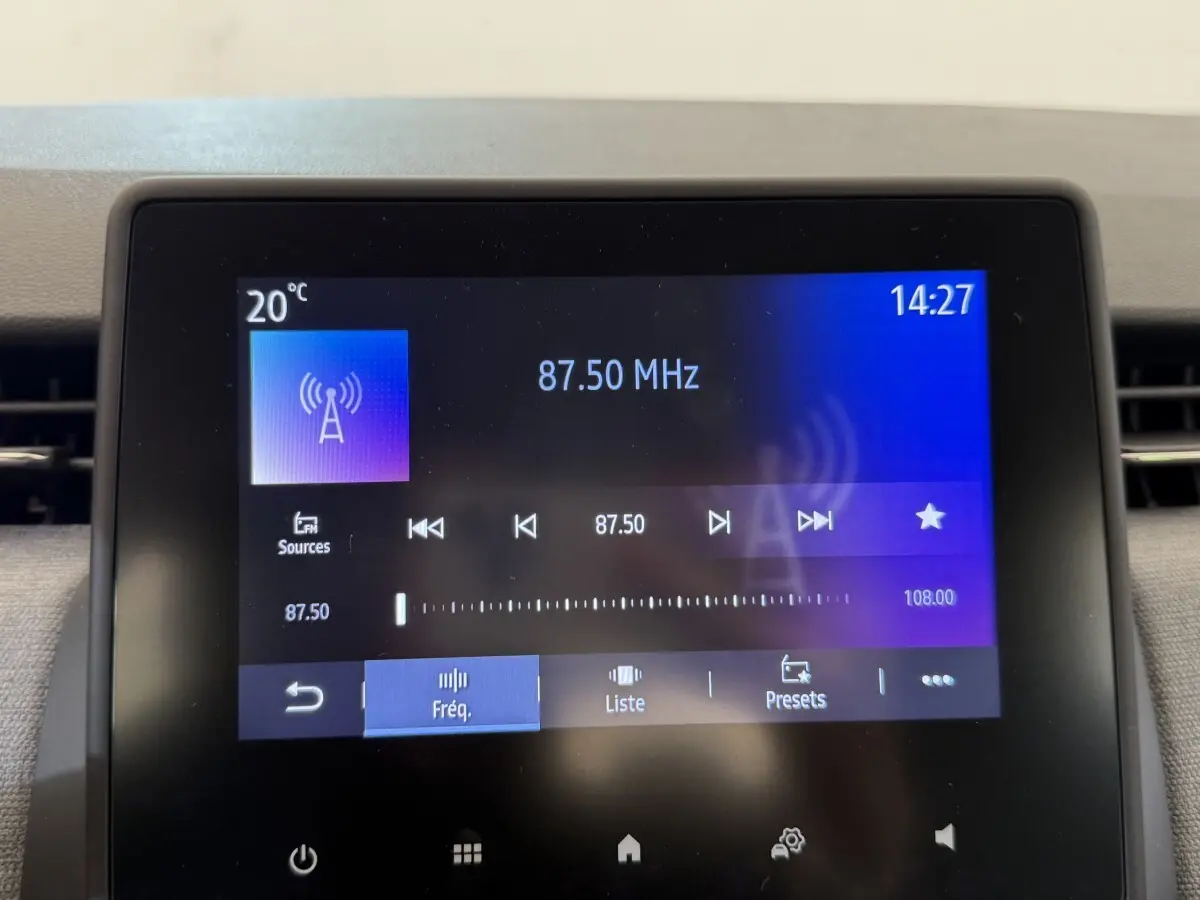 Écran tactile central de la Renault Clio noire 2025 affichant la radio FM à 87,50 MHz à 14h27.