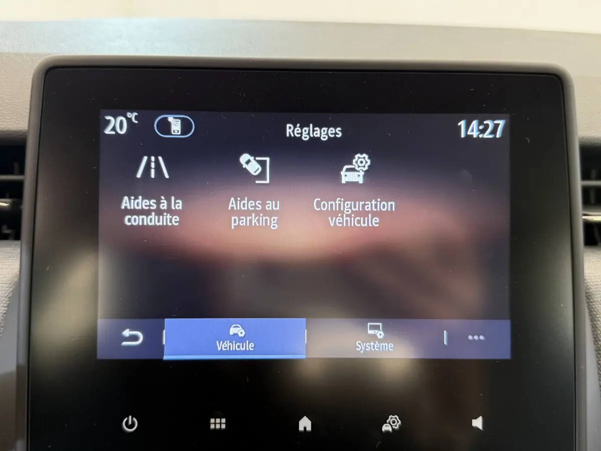 Écran tactile central de la Renault Clio noire 2025 affichant les réglages d'aides à la conduite et au parking.