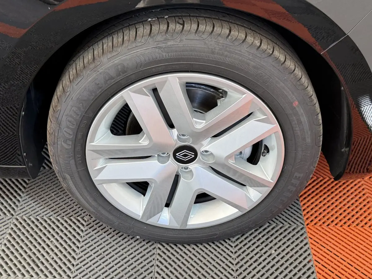 Gros plan sur la roue avant droite noire de la Renault Clio 2025 avec jante argentée au design moderne.