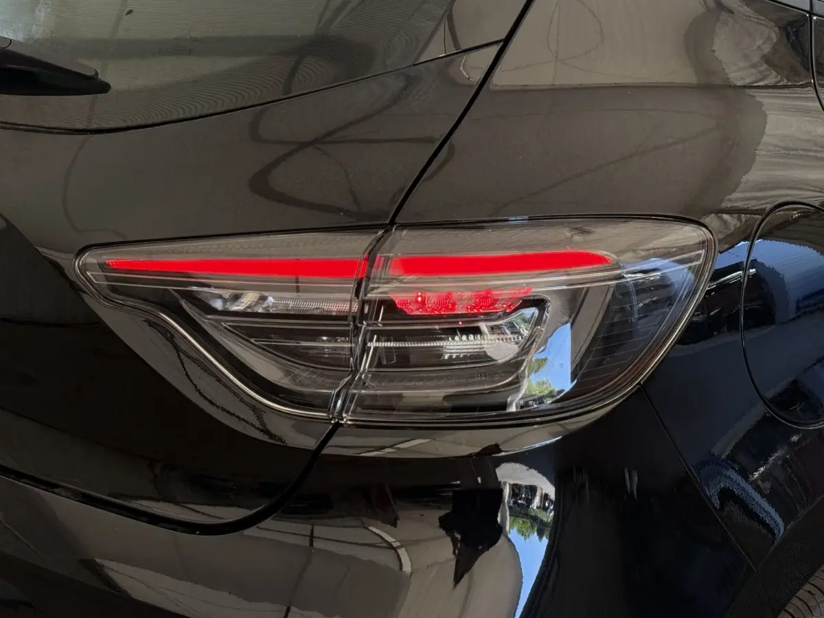 Gros plan sur le feu arrière droit rouge et blanc d'une Renault Clio noire Evolution Blue dCi 100 de 2025