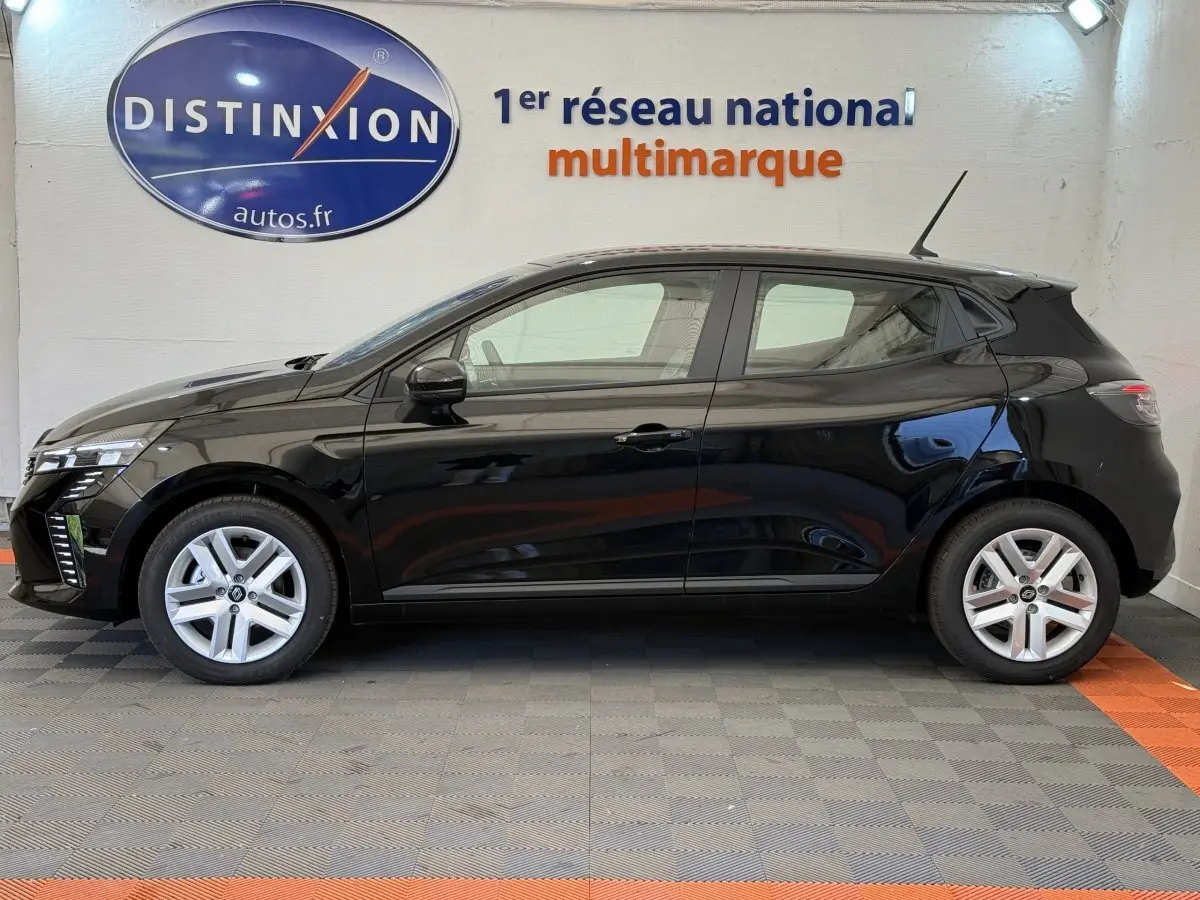 Profil côté gauche d'une Renault Clio noire 2025 garée en intérieur avec jantes argentées et logo Distinxion en arrière-plan.