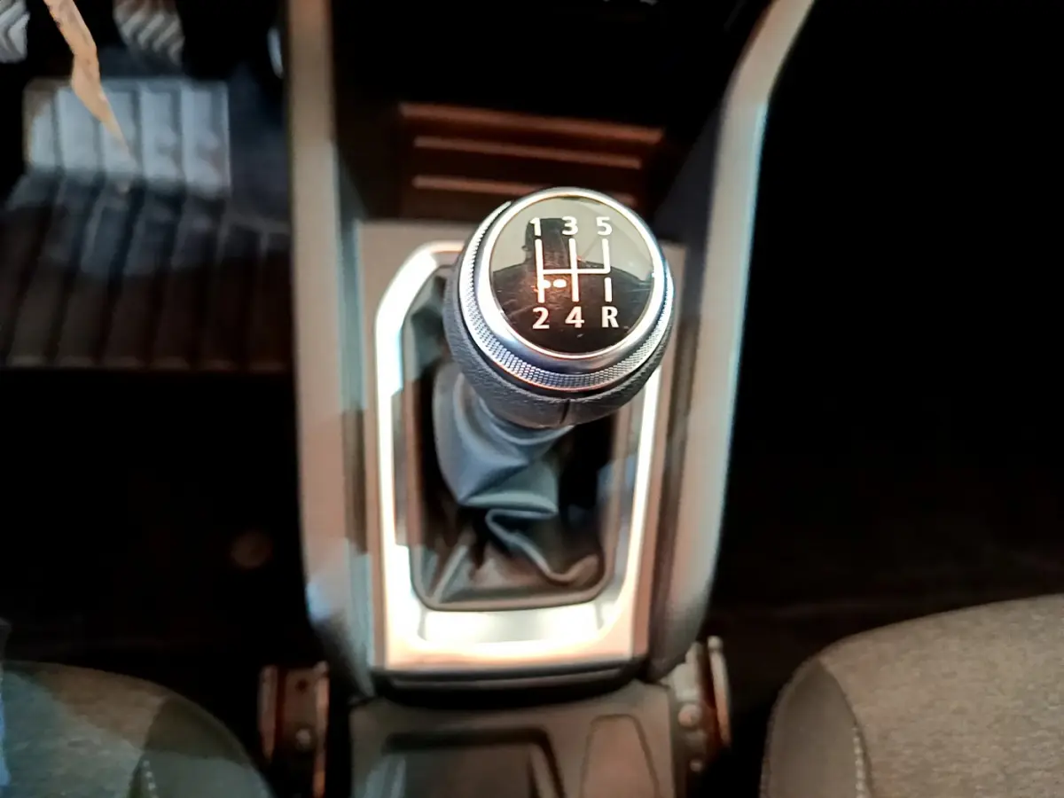 Le levier de vitesse manuel vu de dessus dans l'habitacle sombre d'une Renault Clio Business blanche de 2020.