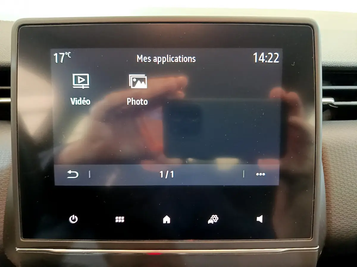 Écran tactile central affichant les applications vidéo et photo dans l'habitacle d'une Renault Clio Business blanche de 2020.
