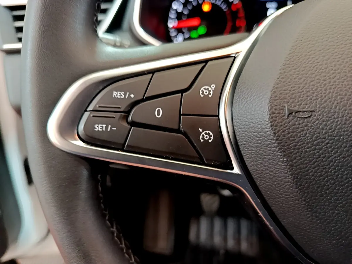 Gros plan sur le volant cuir synthétique noir de la Renault Clio Business TCe 100 avec commandes de régulateur de vitesse.