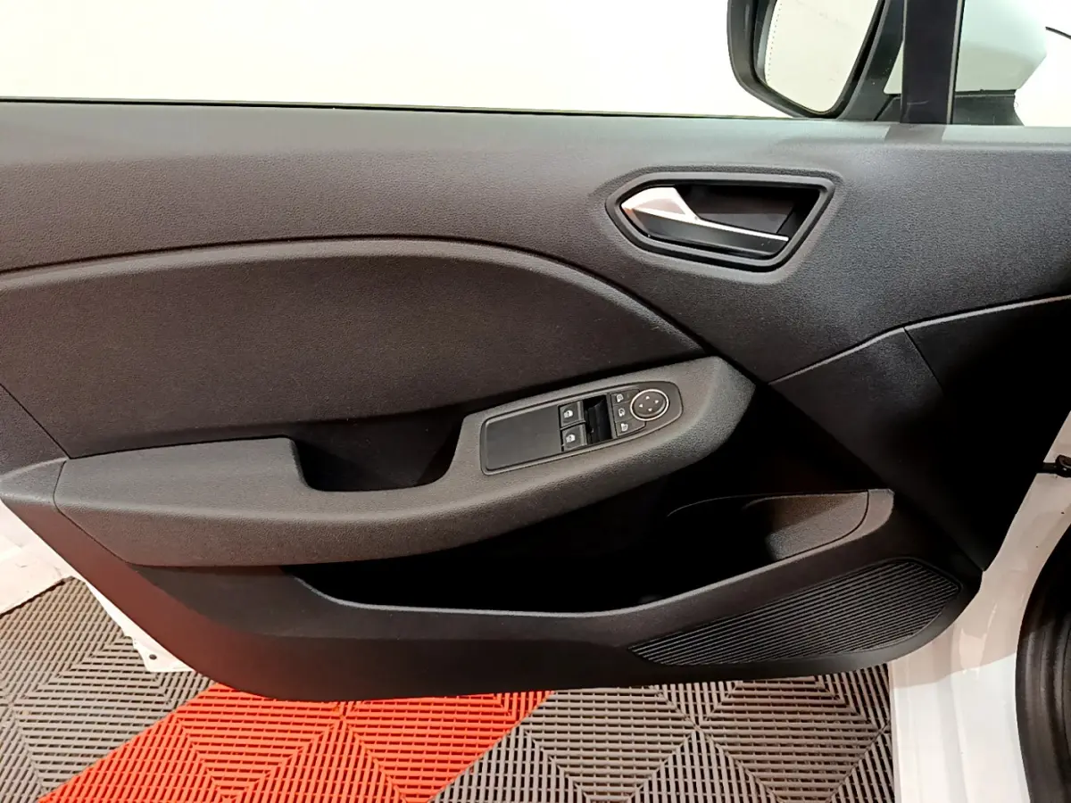 Vue intérieure du panneau de porte côté conducteur de la Renault Clio Business TCe 100 blanc, avec commandes électriques des vitres.