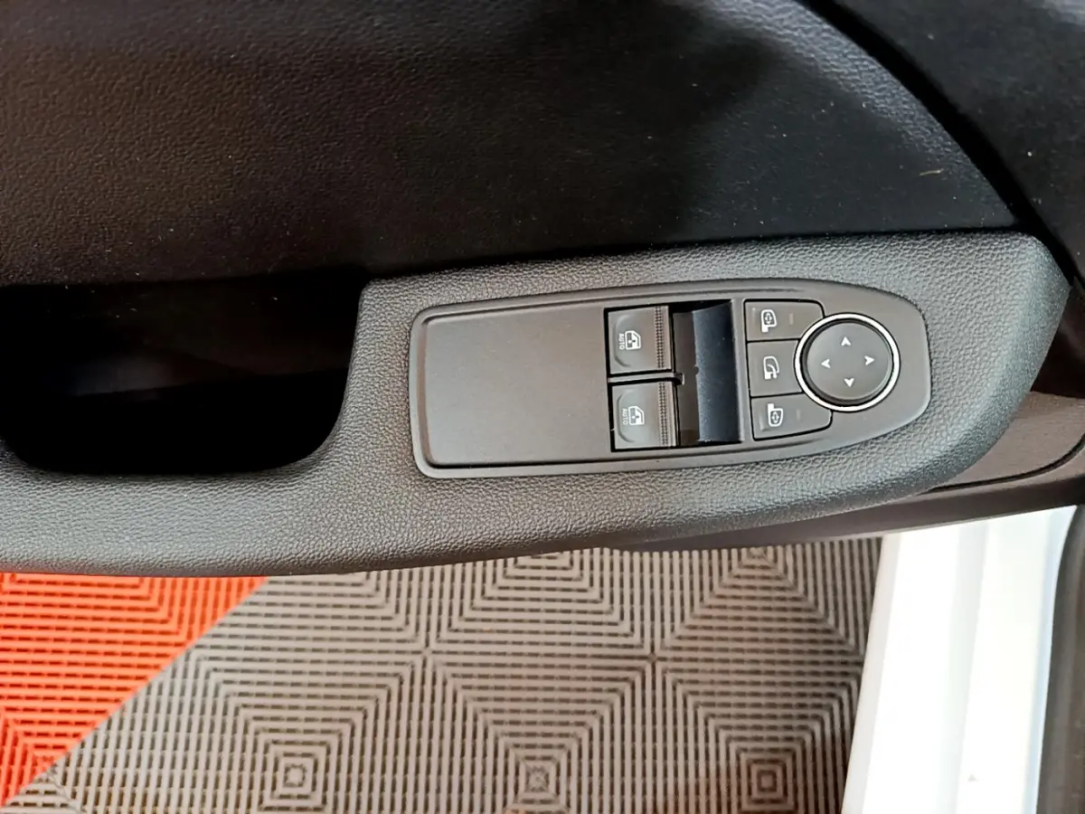 Commandes des vitres électriques et rétroviseurs sur la porte côté gauche d'une Renault Clio Business blanche de 2020.