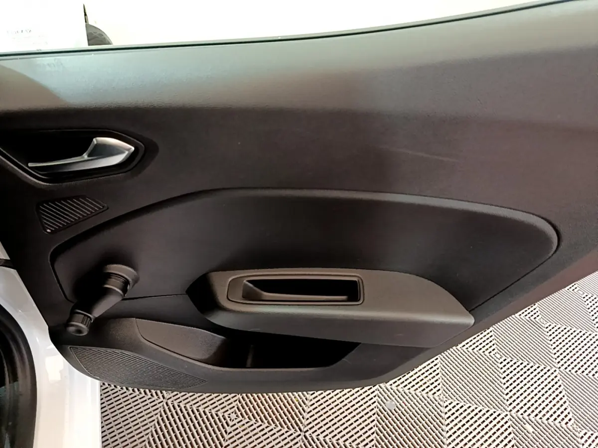 Détail de la porte intérieure côté gauche d'une Renault Clio Business blanche, avec poignée et commande manuelle de vitre.