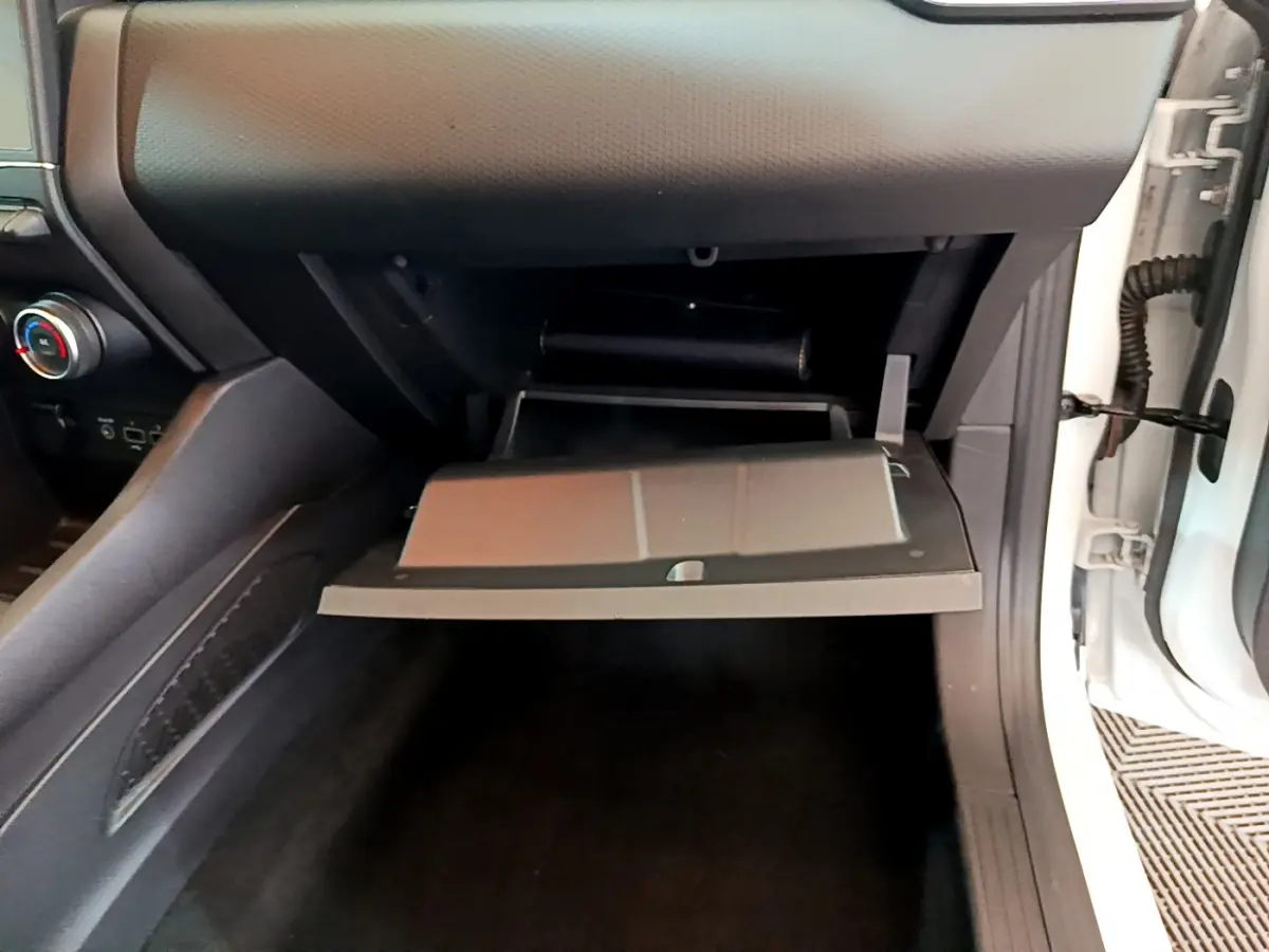 Vue intérieure côté passager de la boîte à gants ouverte dans une Renault Clio Business TCe 100 blanche de 2020.