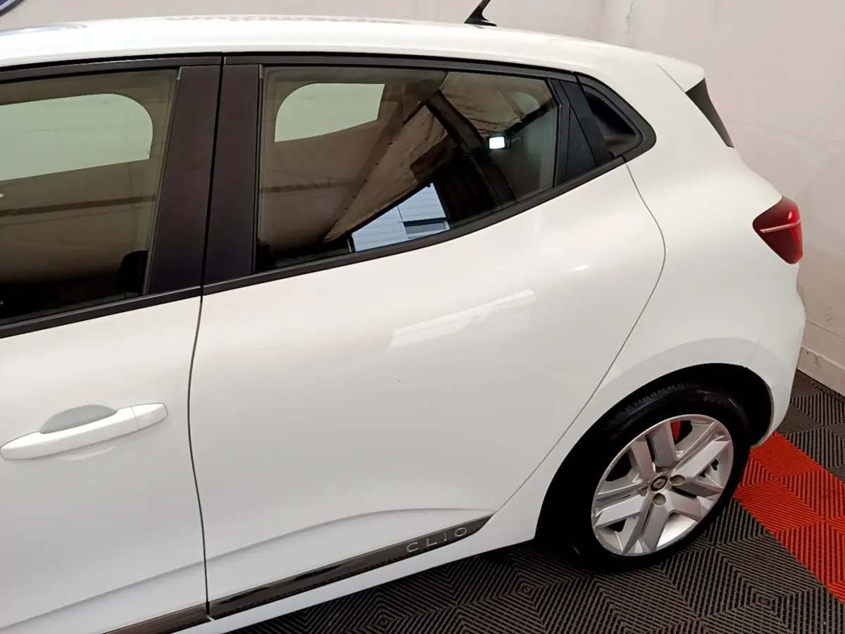 Vue latérale droite rapprochée d'une Renault Clio blanche 2020 avec jantes alliage et poignées de porte intégrées.