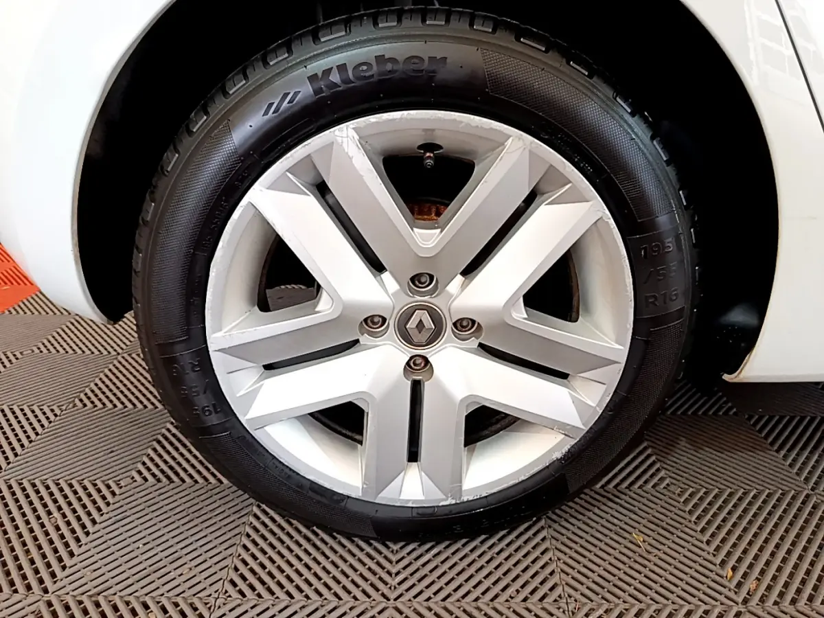 Gros plan sur la roue avant gauche blanche d'une Renault Clio Business TCe 100 avec jante alliage et pneu Kleber.