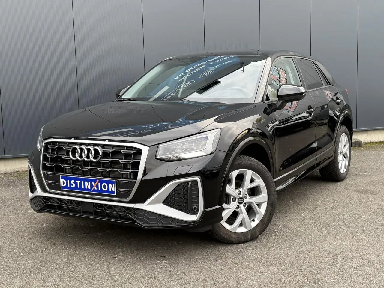Audi Q2 noir Mythe vue 3/4 avant droit, mettant en valeur sa calandre hexagonale et ses jantes alliage 17 pouces.