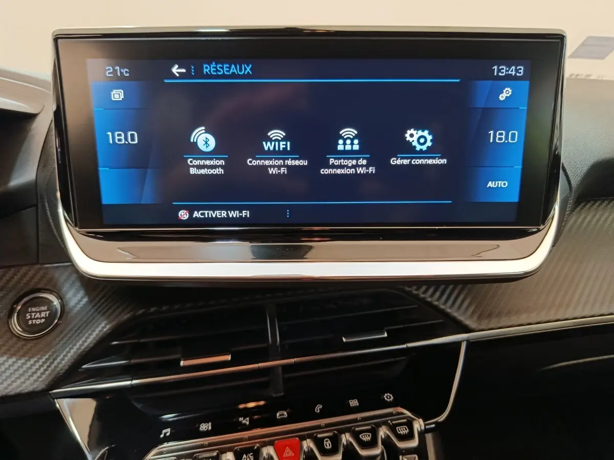 Écran tactile central bleu affichant les options Wi-Fi dans l'habitacle noir de la Peugeot 208 2020.
