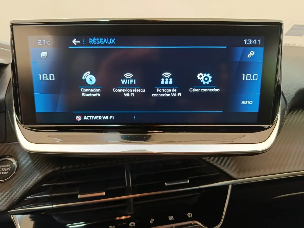 Écran tactile central affichant les options Wi-Fi et Bluetooth dans l’habitacle noir du Peugeot 208 2020.