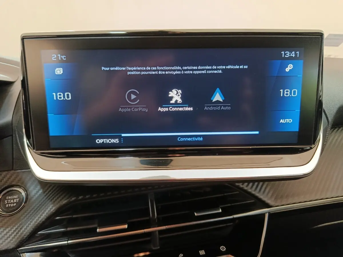 Écran tactile central de 10 pouces affichant Apple CarPlay et Android Auto dans le tableau de bord d'une Peugeot 208.