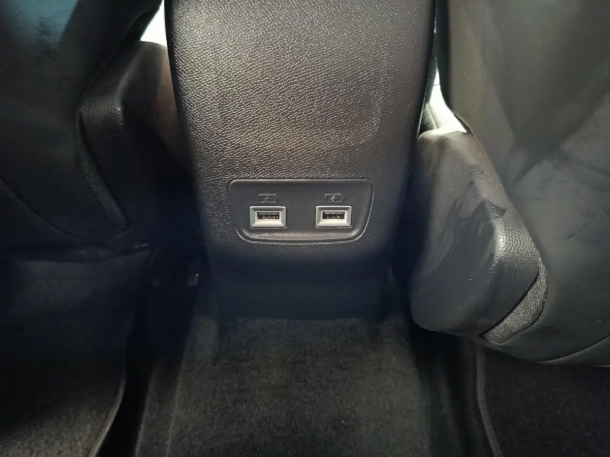 Prise USB double vue en gros plan à l'arrière de la console centrale d'une Peugeot 208 2020 noire.
