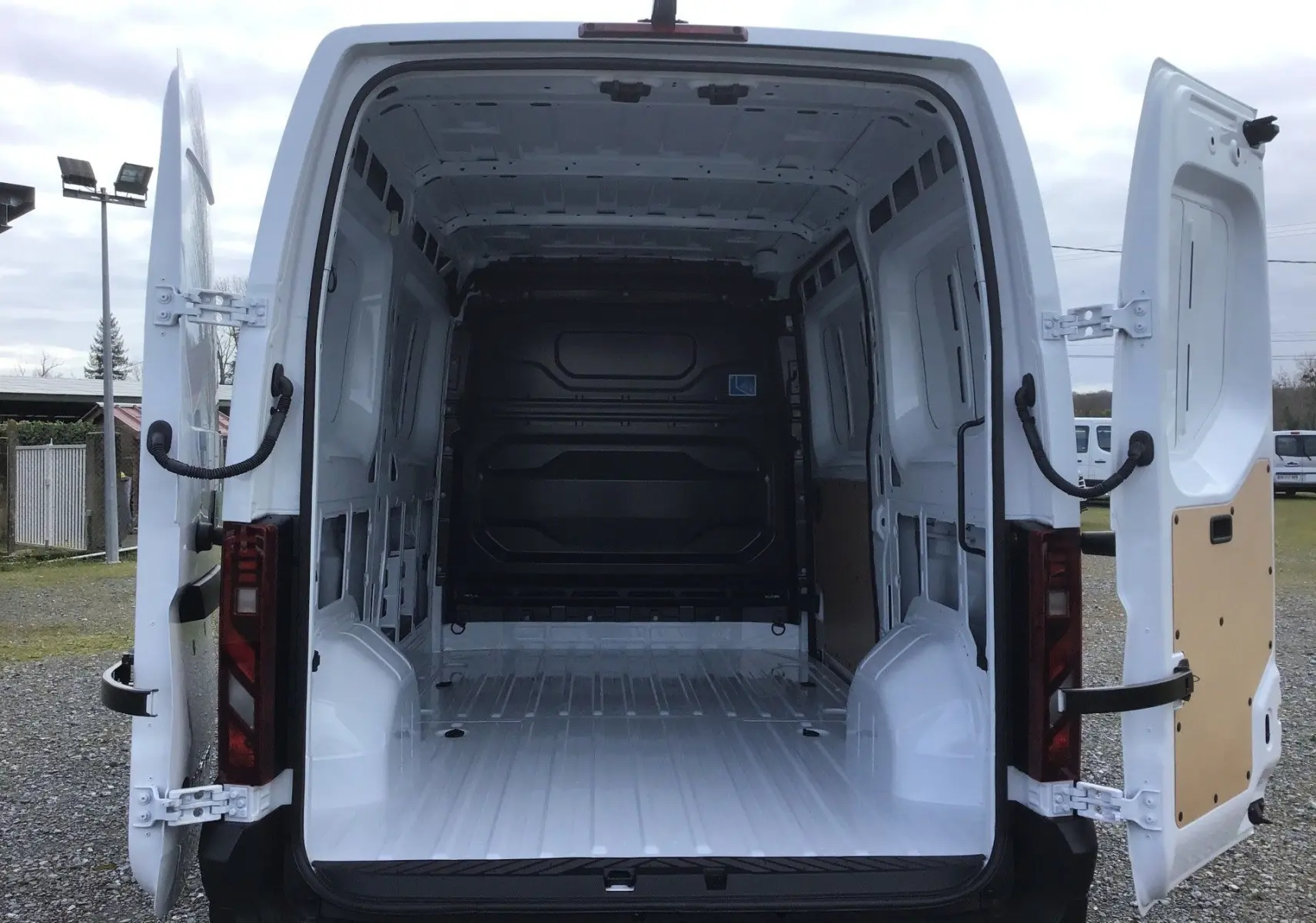 Vue arrière du Renault Master blanc L2H2 avec portes ouvertes montrant la grande zone de chargement vide et spacieuse.