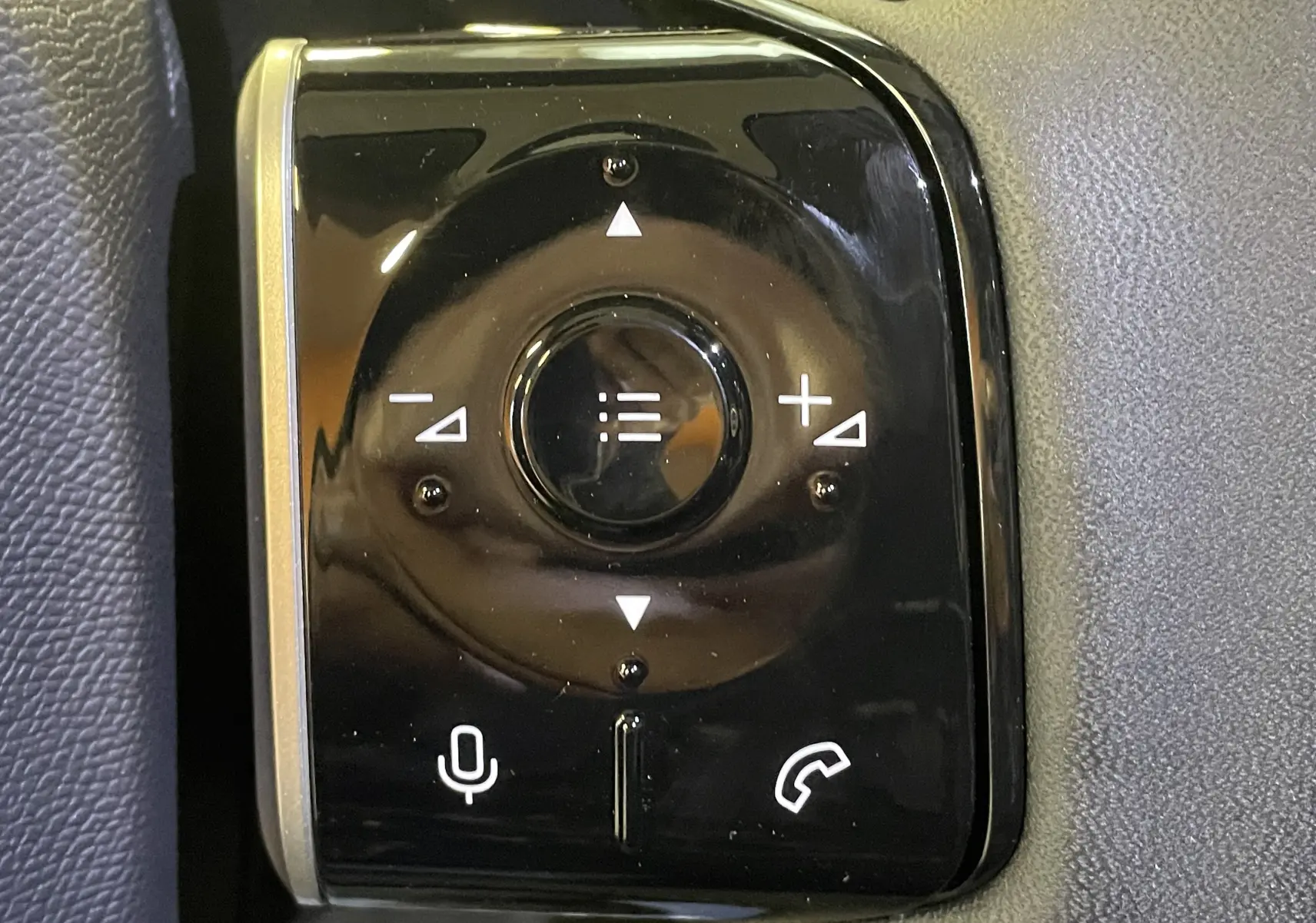 Gros plan sur les commandes au volant noir brillant du Citroën C5 Aircross hybride 2026, avec boutons de volume et téléphone.