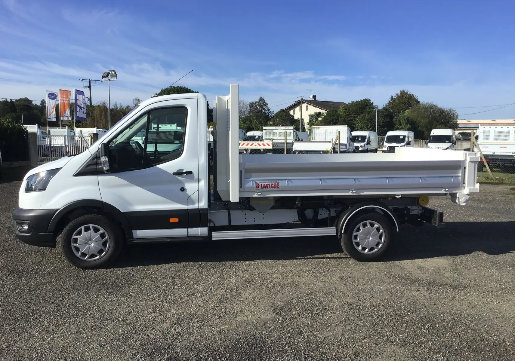 Ford Transit Chassis Cabine blanc vu de profil côté gauche avec benne basculante et bras polybenne.